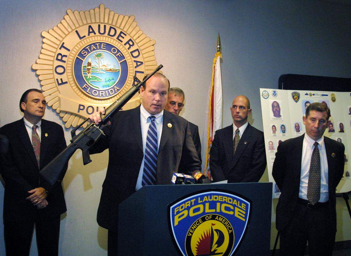 Fort Lauderdale Police Capt. Paul Kiley holds up an AR-15 firearm that was confiscated during the arrest of several members of a home invasion robbery and drug ring in 2004. Kiley is now the director of the Miami Dade College School of Justice.