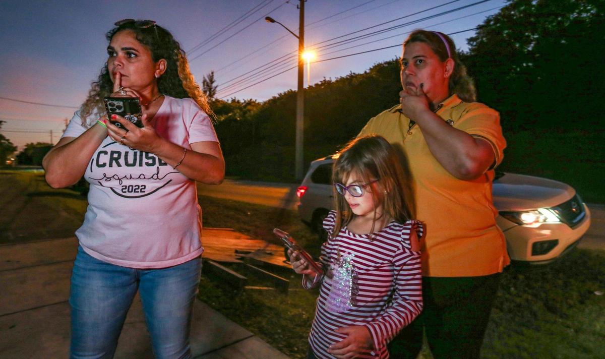 Yarileisy Sierra and Yayli Trujillo and her daughter, Maylee del Valle, 7, wait for the arrival of Cuban family members at the Border Patrol Station in Dania Beach, Florida, on Thursday, Jan. 5, 2023.