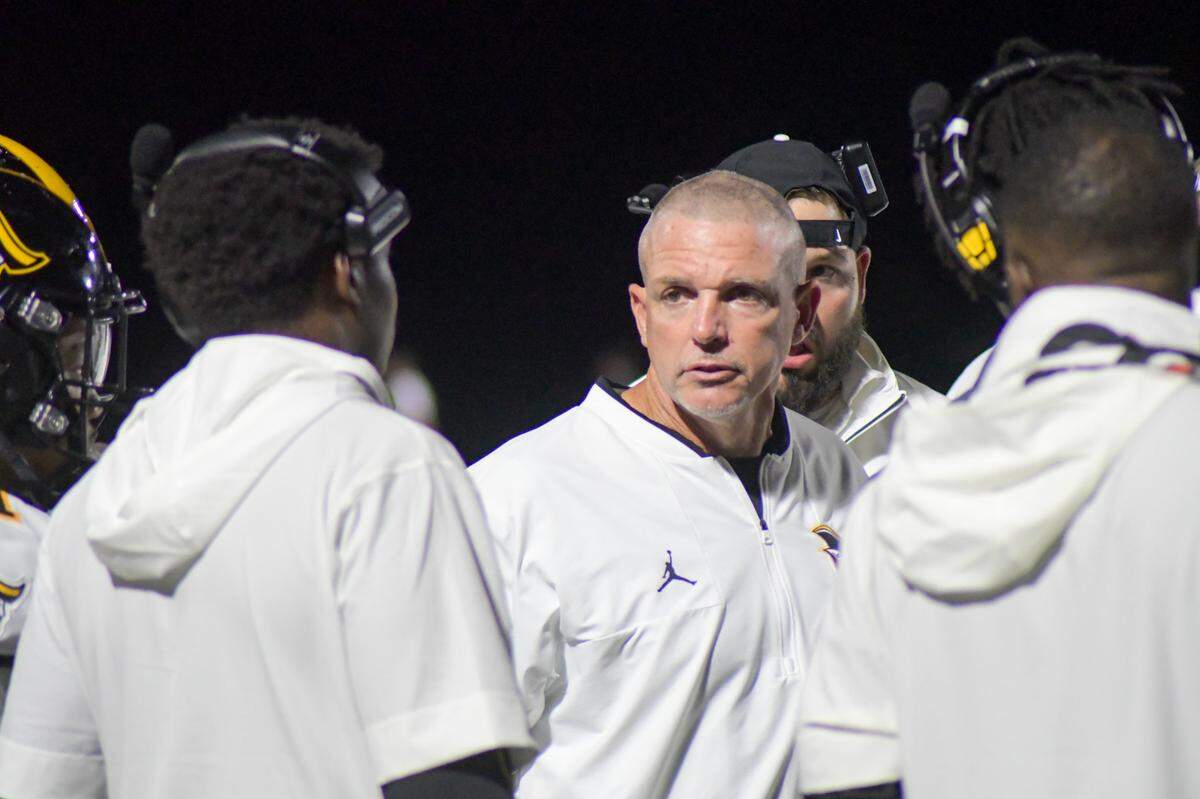 American Heritage coach Mike Smith talks with his staff during a timeout against Milton on Friday, Aug. 23, 2024, in a Broward County High School National Football Showcase game at St. Thomas Aquinas in Fort Lauderdale, Florida.