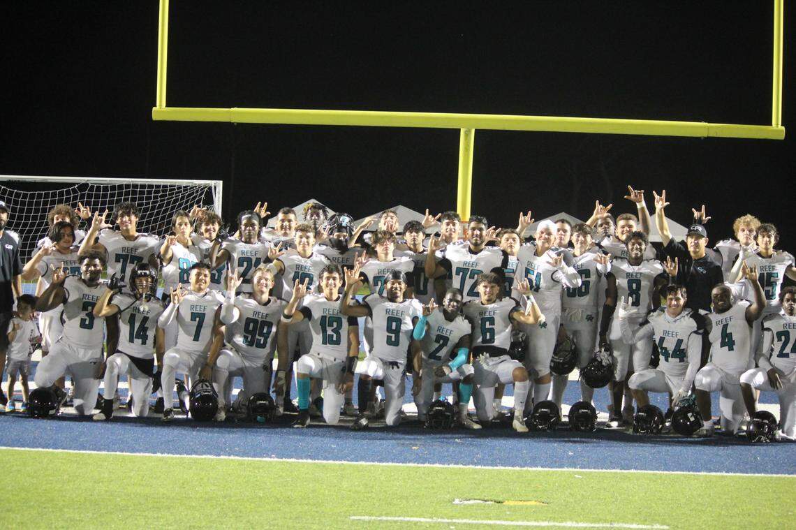 Players from the Coral Reef football team celebrate after defeating Braddock on Friday night at Tropical Park to win the GMAC Independent schools championship.