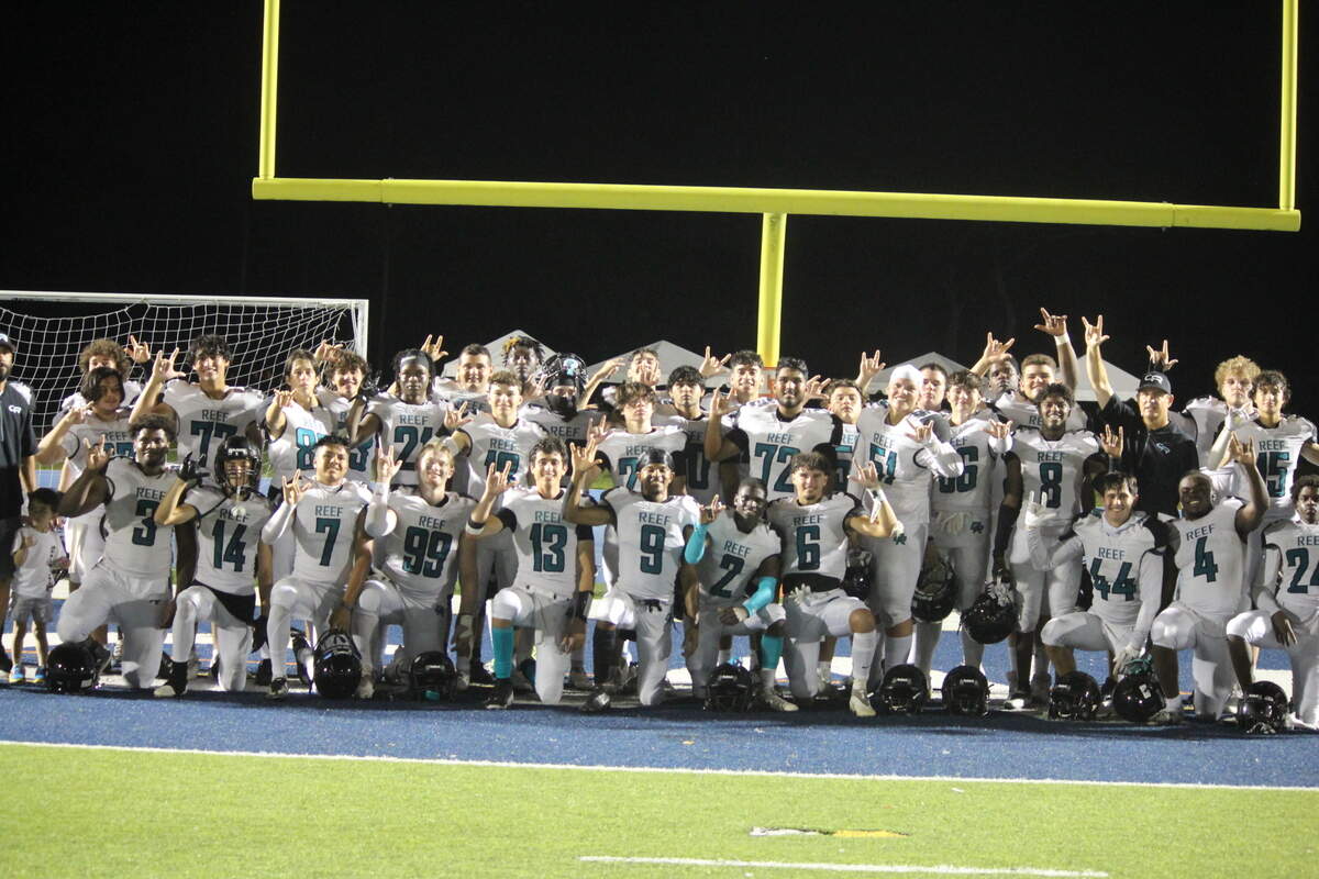 Players from the Coral Reef football team celebrate after defeating Braddock on Friday night at Tropical Park to win the GMAC Independent schools championship.