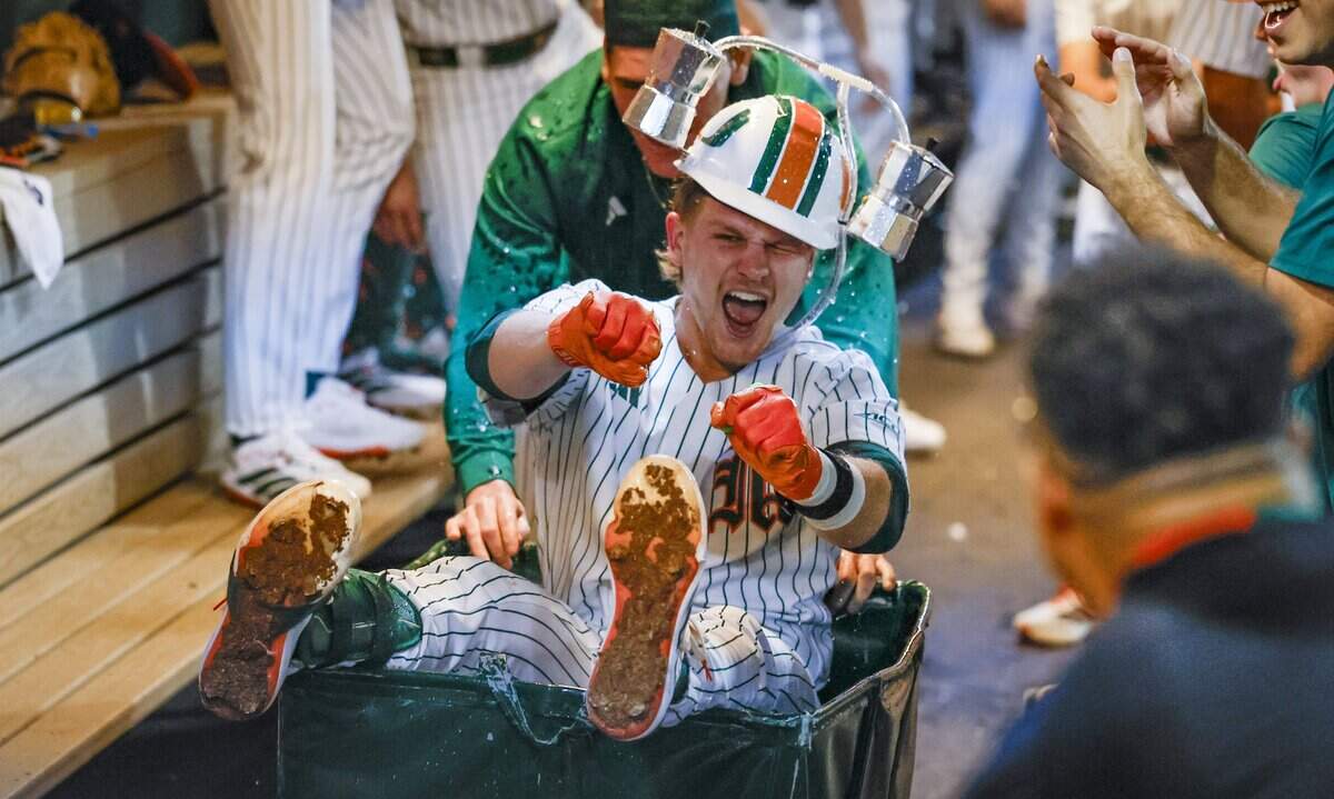 Miami Hurricanes catcher Alex Sosa (13) celebrates in the dugout after scoring a homerun in the third inning against the Lehigh Mountain Hawks during the Hurricanes season opener at Mark Light Field in Coral Gables, Florida, Florida on Friday, February 13, 2026
