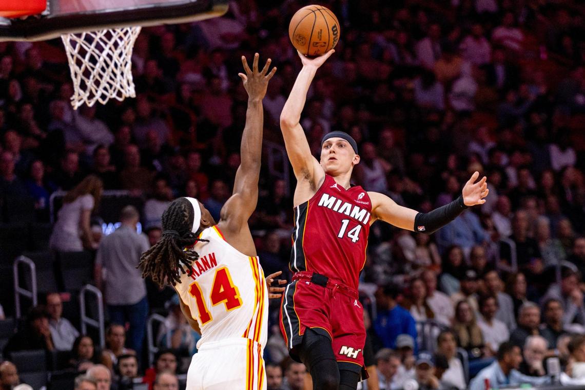 Miami Heat guard Tyler Herro (14) floats the ball over Atlanta Hawks guard Terance Mann (14) during the second half of an NBA game on Wednesday, February 26, 2025, in Miami.
