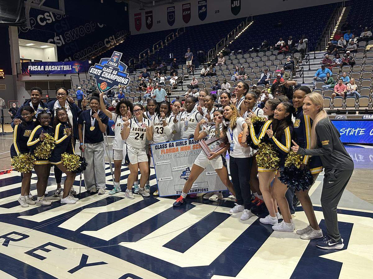 St. Thomas Aquinas’ girls’ basketball team celebrates after beating Palm Bay Bayside for the Class 6A state championship on Saturday at UNF Arena in Jacksonville, Fla.