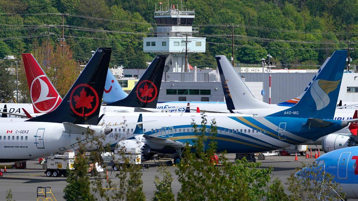 Boeing 737 Max airplanes, belonging to Air Canada and other airlines, sit parked in a storage lot, Monday, April 26, 2021, near Boeing Field in Seattle. Two travelers flew from the U.S. to Toronto and submitted fraudulent vaccination cards and negative COVID tests, the Public Health Agency of Canada said.