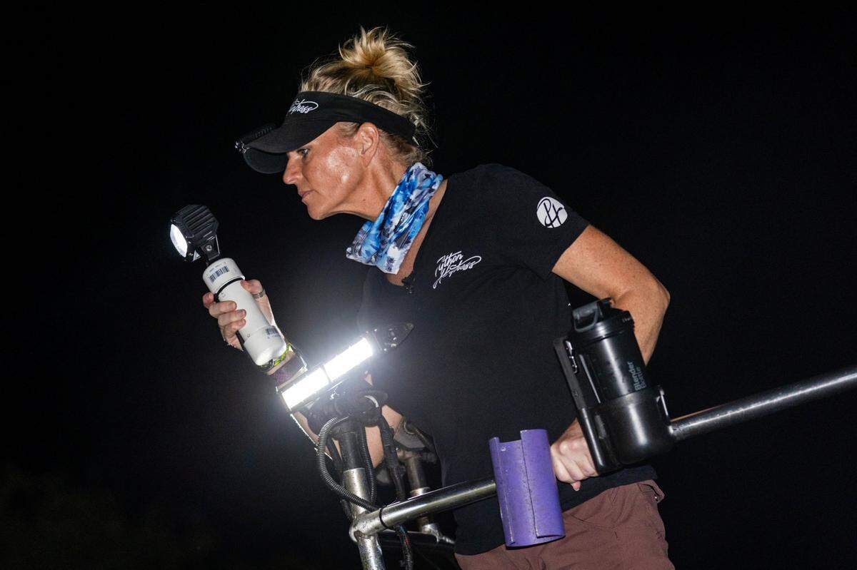 Amy Siewe searches for pythons using a flashlight on the lifted bed of the truck she calls the “snake deck.”