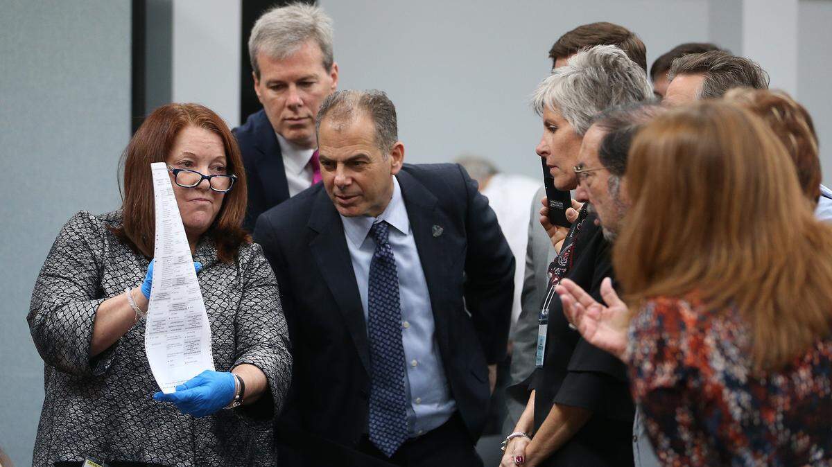 Canvassing Board member Judge Deborah Carpenter-Toye, left, reviews voter intention on a ballot as attorney Joseph M. Goldstein of Shutts & Bowen leans in for a closer look as the recount continues in Broward County on Thursday, Nov. 15, 2018.