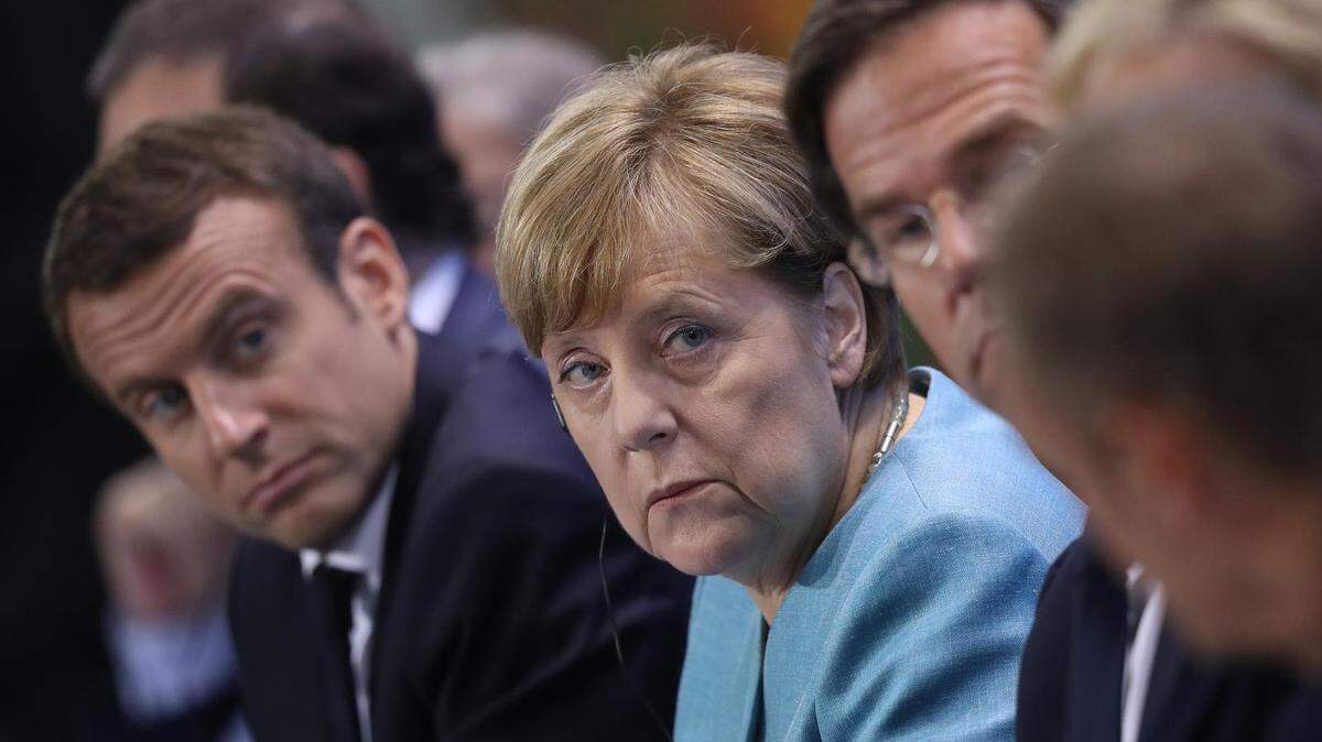 Emmanuel Macron, Angela Merkel and other European Union leaders speaking to the media.