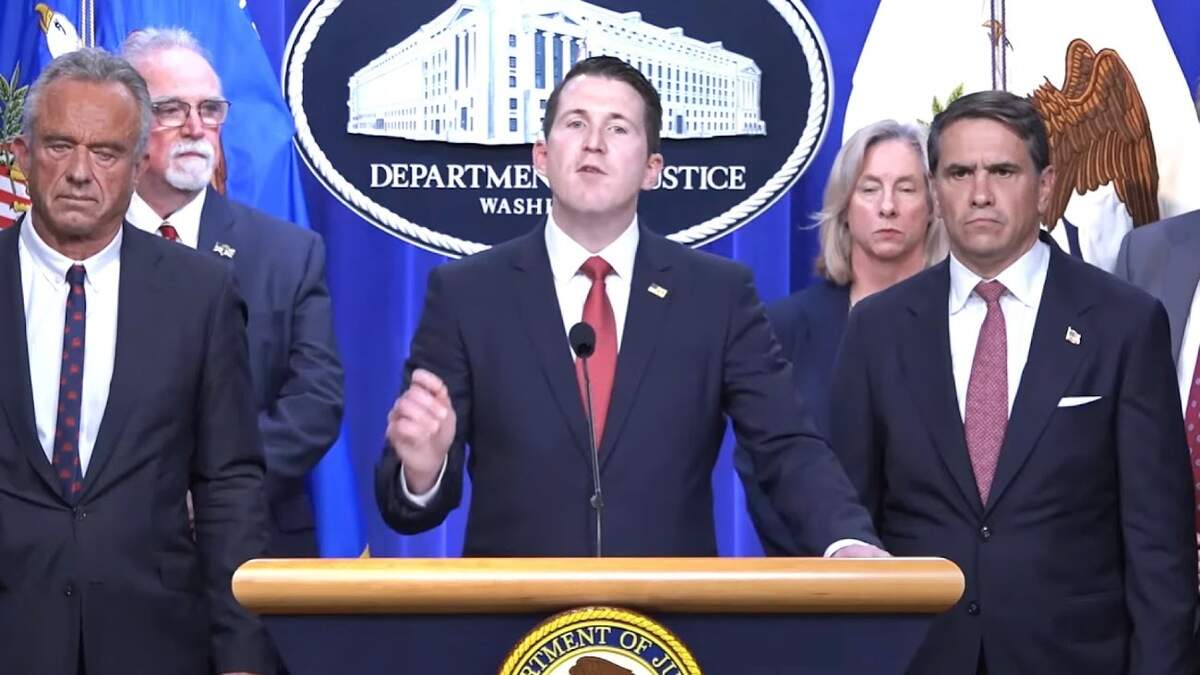 Assistant Attorney General Colin McDonald speaks at a news conference to announce the results of a two-week healthcare fraud operation on June 23, 2026. He is flanked by Health and Human Services Secretary Robert F. Kennedy Jr., left, and Acting Attorney General Todd Blanche.