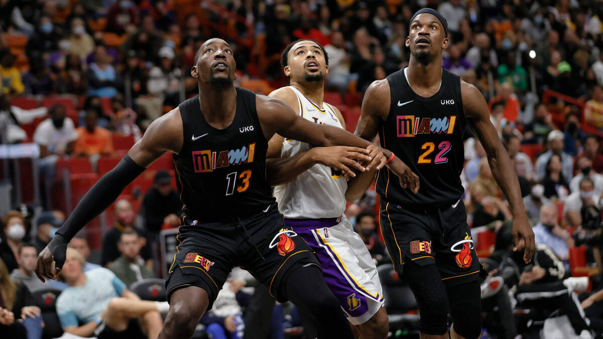 El centro del Heat Bam Adebayo (izq.) y el alero Jimmy Butler luchan por un rebote contra el escolta de los Lakers de Los Angeles, Talen Horton-Tucker, en el partido celebrado el 23 de enero de 2022 en el FTX Arena de Miami.