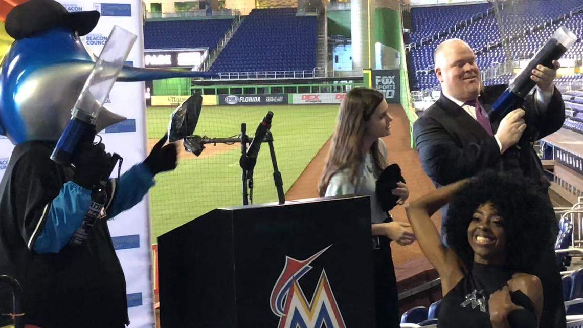 Mark Trowbridge, president and CEO of the Coral Gables Chamber of Commerce, gets help from the Marlins team  as he shoots T-shirts to attendees at Wednesday’s annual report on the Beacon Council’s One Community One Goal initiative This year’s event was held at Marlins Stadium.