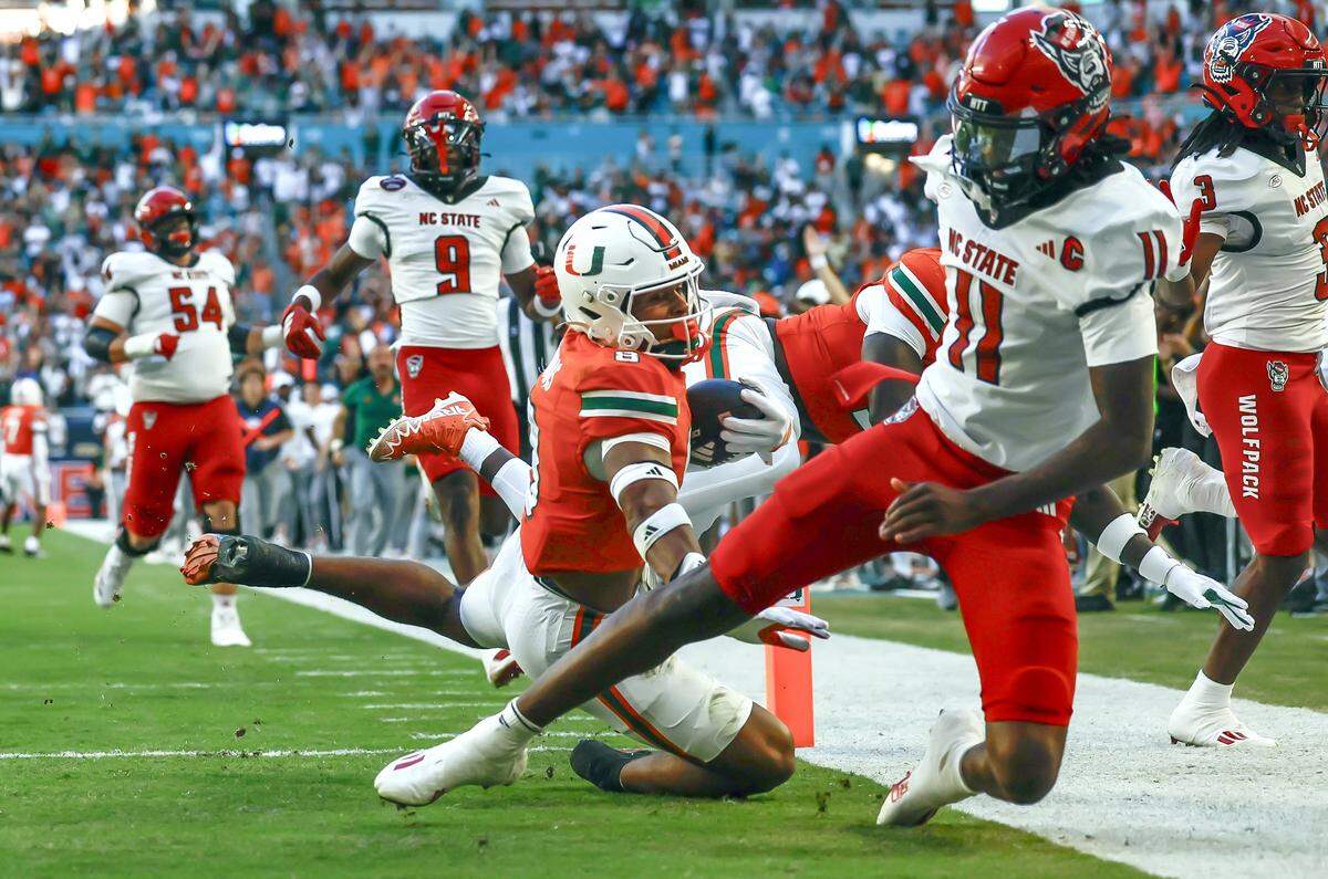 Miami Hurricanes defensive back Jakobe Thomas (8) intercepts for a touchdown in the first half of an NFL football game against the NC State Wolfpack at Hard Rock Stadium in Miami Gardens, Florida, on Saturday, November 15, 2025. 