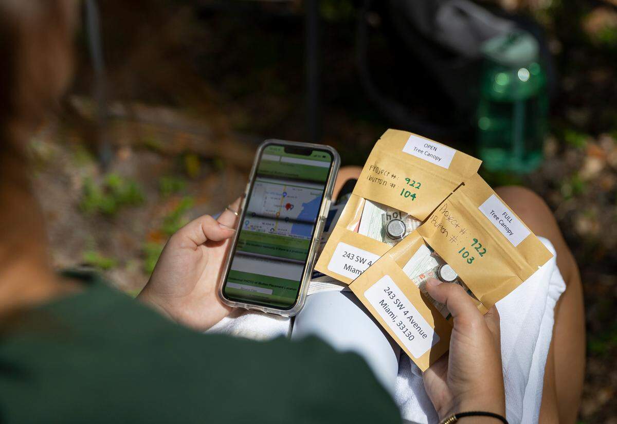 Peyton Collado, 22, a University of Miami student, holds a set of heat sensors during a citizen science event at Legion Park on Saturday, Sept. 10, 2022, in Miami, Fla. The “Shading Dade” event invited members of the public to help place heat sensors in specific locations to help record temperatures across Miami-Dade County.