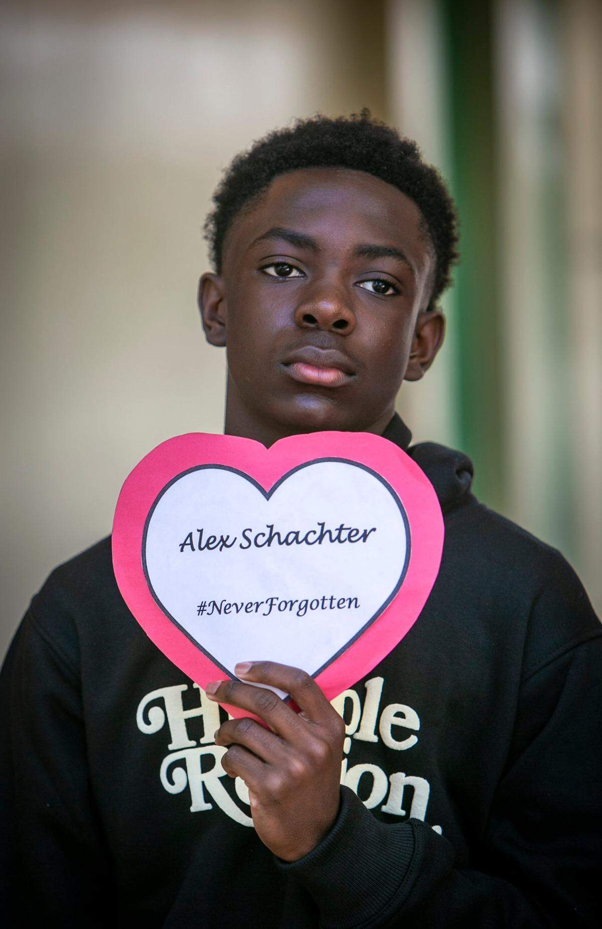 Seventh-grade student Dojuan June holds a heart bearing the name of Alex Schachter, who died in the shooting at Marjory Stoneman Douglas High School in 2018, during a ceremony Tuesday, Feb. 14, at Silver Lakes Middle School in North Lauderdale.