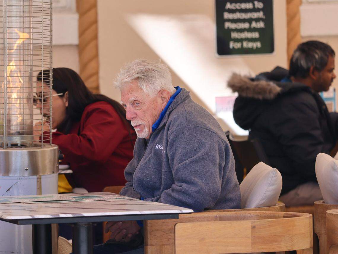 A diner leans toward a space heater as tourists walked, dined and visited the beach as a cold snap brought Arctic blasts to Miami Beach’s Art Deco District on Feb. 1, 2026.