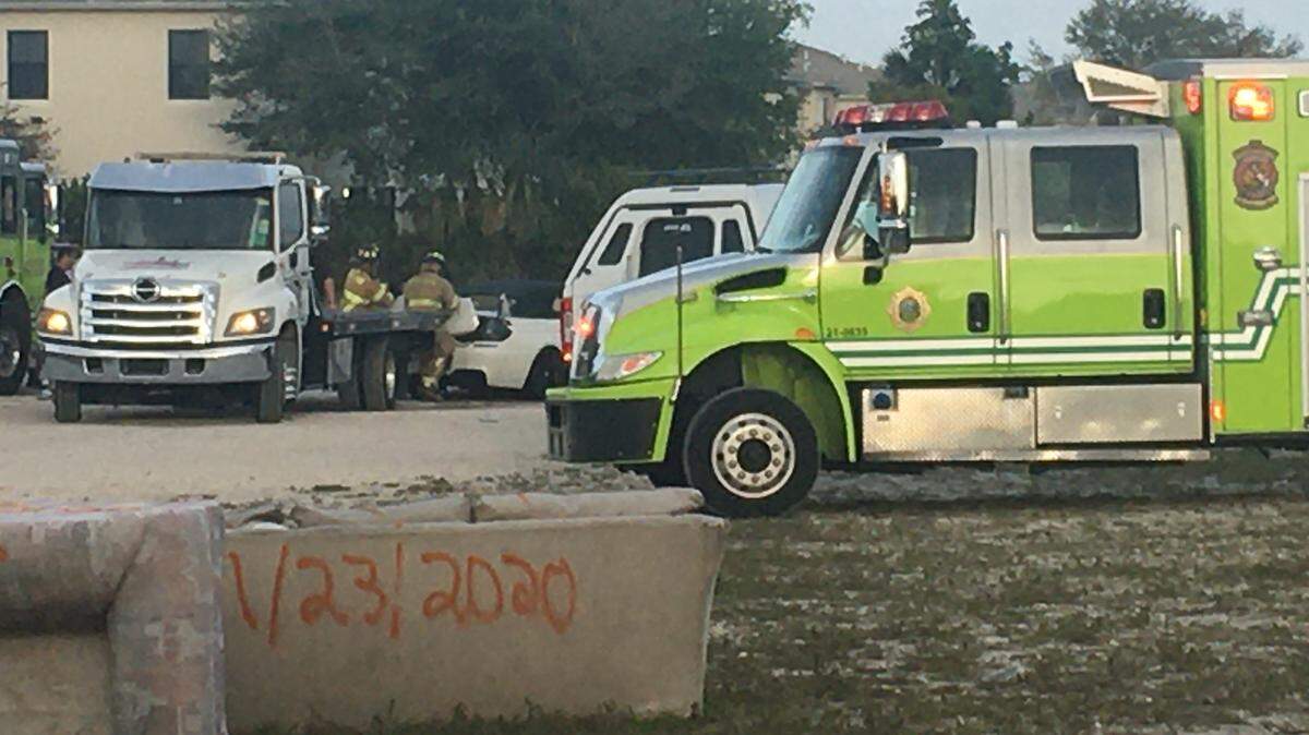 Miami-Dade Fire Rescue crews cut open the trunk of a white BMW that had been towed out of a canal in Miami Gardens March 3, 2020.