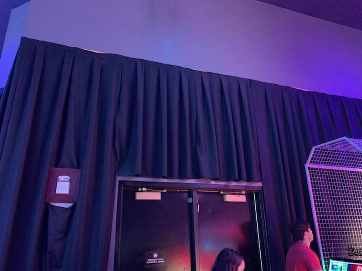 Exit signs are blocked by black curtains at Dave & Busters at Dolphin Mall.