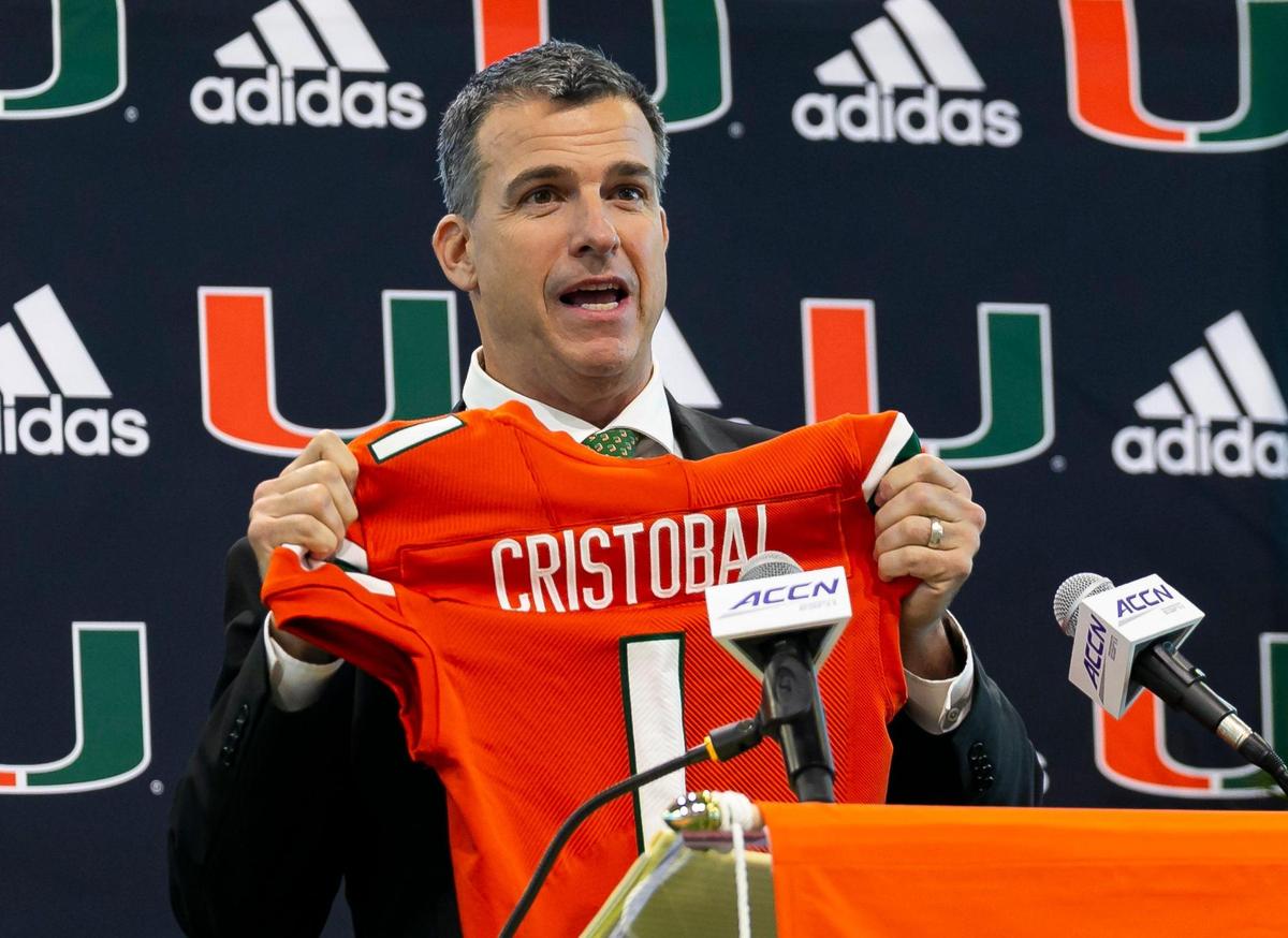 Mario Cristobal, the newly hired head football coach of the Miami Hurricanes, reacts after being given a jersey during a press conference at the Carol Soffer Indoor Practice Facility inside the University of Miami in Coral Gables, Florida on Tuesday, December 7, 2021.