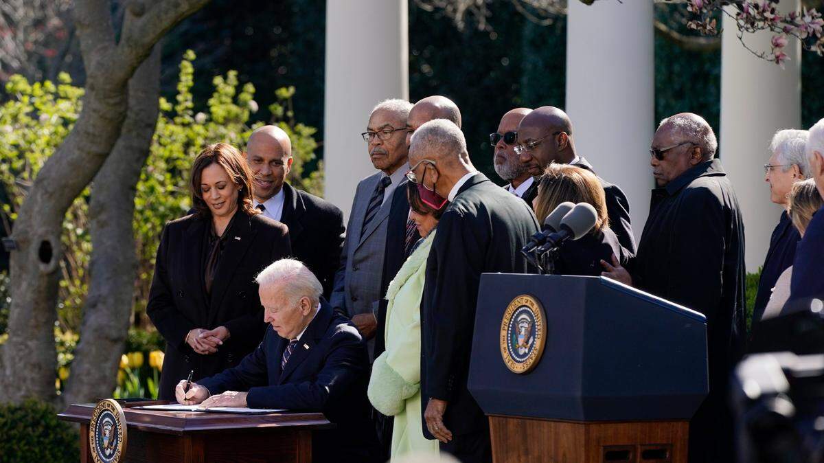 Flanked by Vice President Kamala Harris, left, and several others, President Joe Biden signs the Emmett Till Antilynching Act in the Rose Garden of the White House on Tuesday, March 29, in Washington.