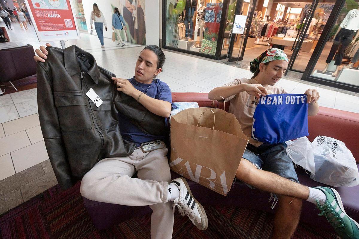 Zara or Urban Outfitters? Perhaps both will do. Juan Agustín Stacey (left) and Joaquín Stacey (right) check out some of the items they purchased at Dadeland Mall on Black Friday, Nov. 29, 2024.