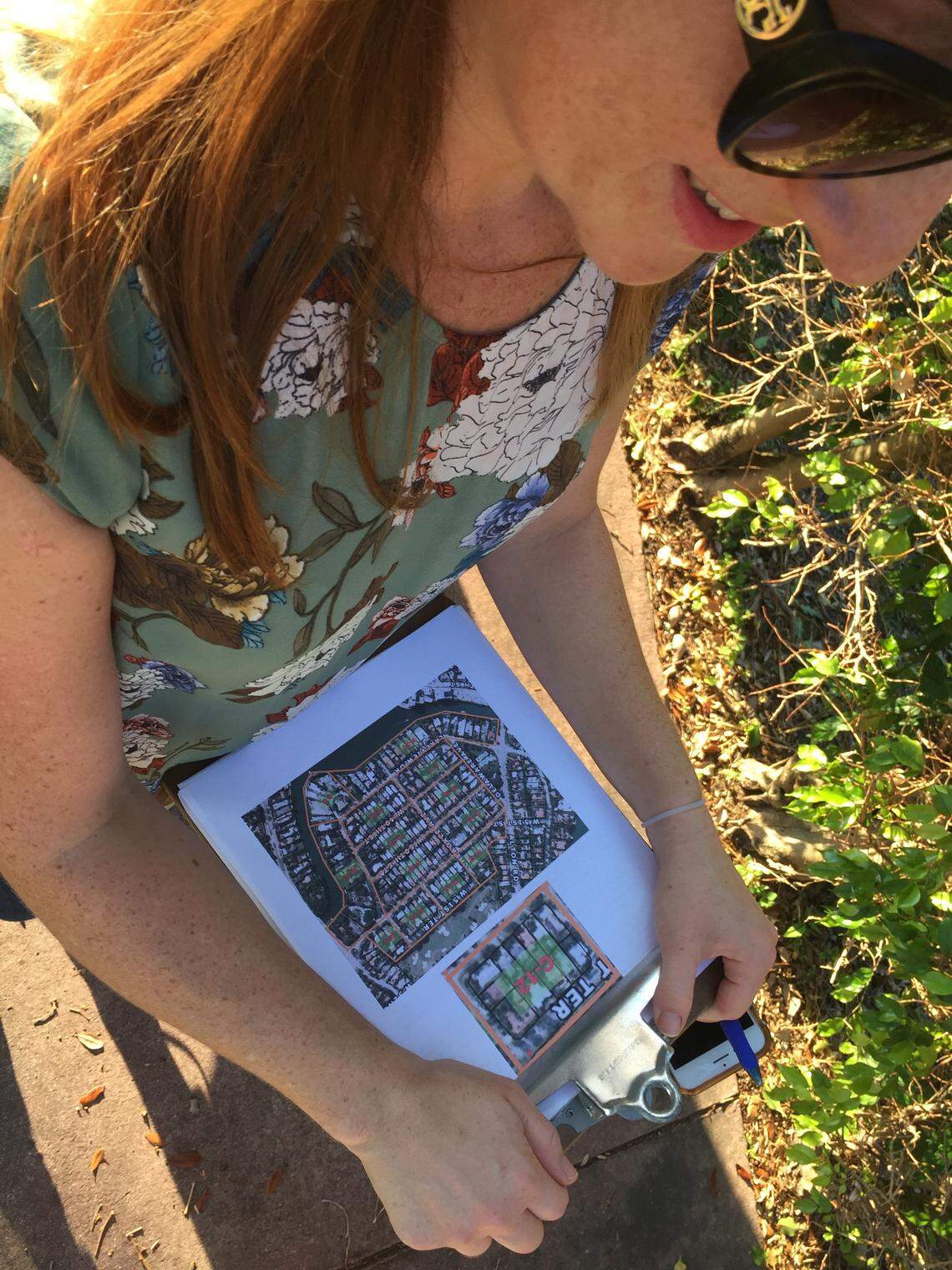 Rina Bass, 32, walks through her Lakeview neighborhood with a chart breaking down which doors she needs to knock on as part of her efforts to stop Miami Beach’s planned project to make Lakeview climate-change ready by raising roads.