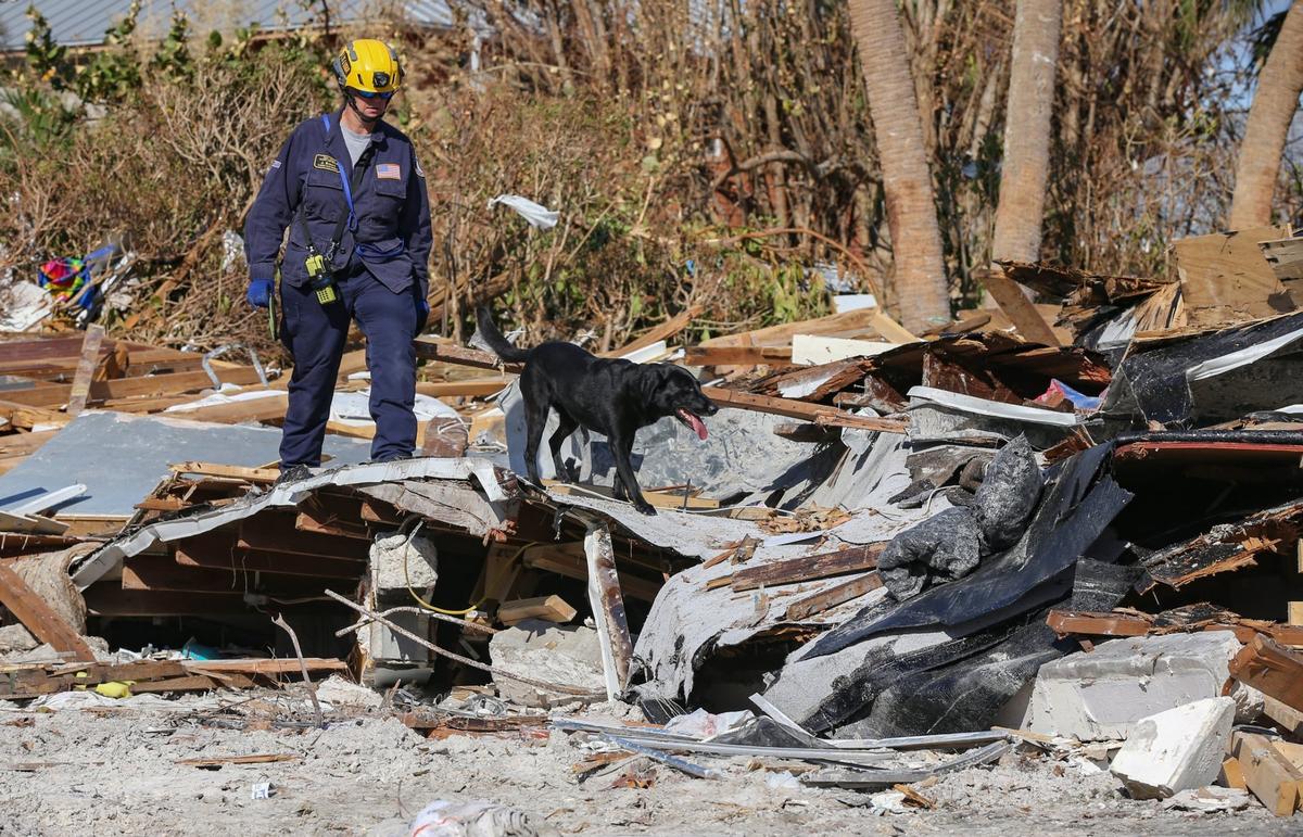 Urban Search and Rescue Florida Task Force 2 team member J. Brown searches a damaged home with search and recovery dog Phame on Fort Myers Beach on Monday, Oct. 3, 2022.