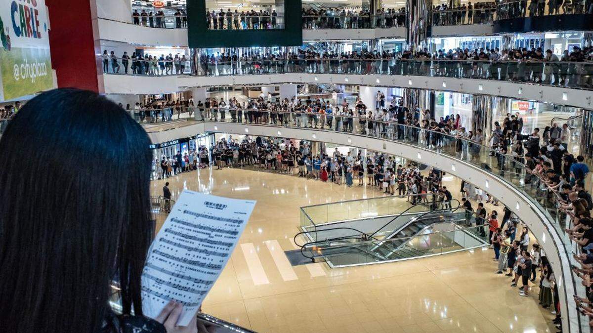 Protesters sing and shout slogans at Hong Kong’s Cityplaza shopping mall after business hours.