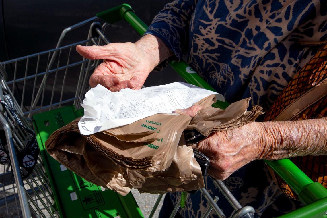 Former Miami High substitute teacher Ricki Weyhe holds a receipt listing cat treats, water bottles and chicken noodle soup she purchased at a Publix in South Miami, Florida, on Friday, Nov. 26, 2021.