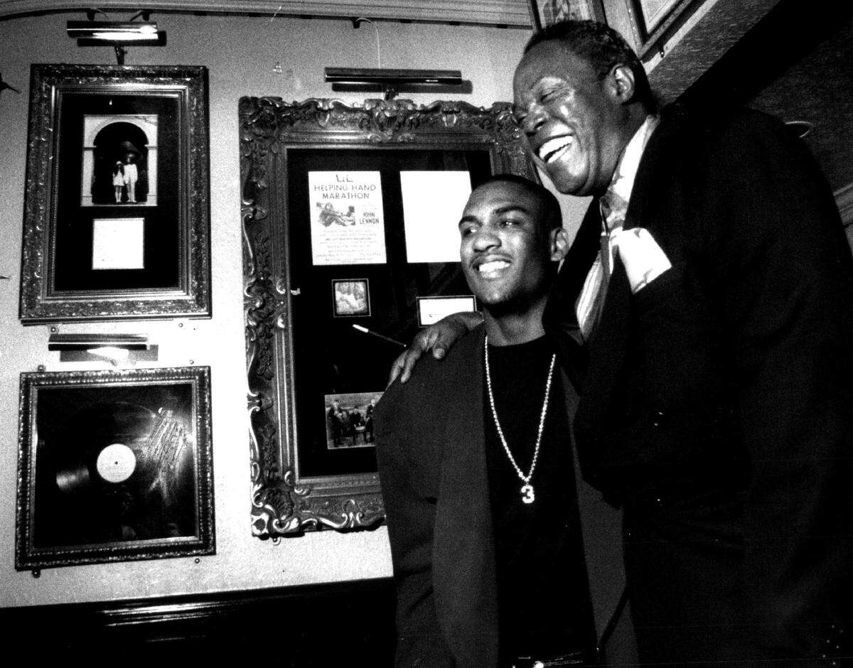 At an event at the Hard Rock Cafe in 1993 to benefit the Camillus House, an observer gets his picture taken with Sam Moore, right, of Sam & Dave.