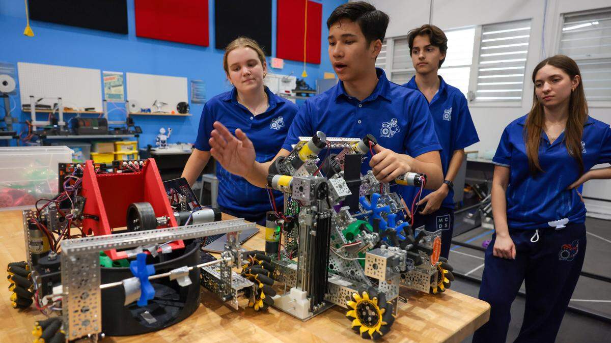 Reece Liu, a 10th grader and member of the Cyber Spartans robotics team, discusses the robot the team will enter in the Florida state championship during a presentation at the Garner Center for Innovation at Miami Country Day School at 601 NE 107th St., on Monday, March 2, 2026, in Miami. Fla. Liu is joined by team captain Cameron Schoch, left, team member Martin Parker Sierra, and team member Maia Mandel, right.