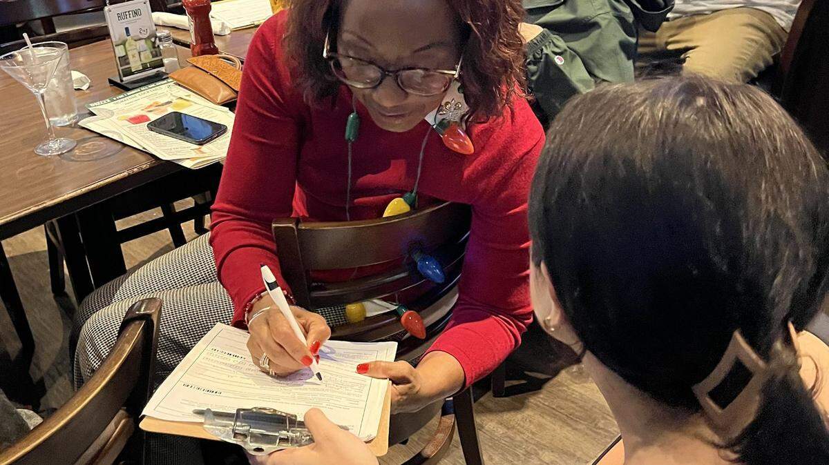 Marvis Williams signs a petition to put abortion access on the 2024 Florida voter ballot, on Dec. 14, 2023, in Plantation.