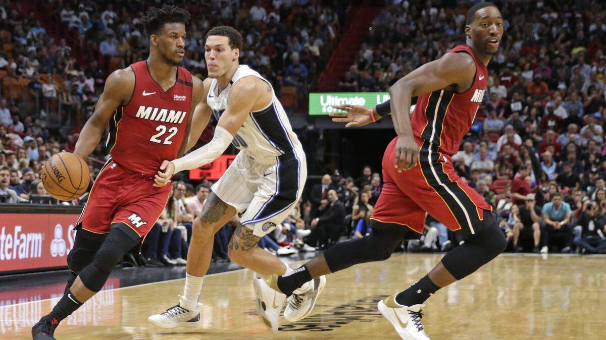 El centro del Heat, Bam Adebayo (13) corta cuando el delantero del Heat Jimmy Butler (22) conduce contra el alero del Magic Aaron Gordon (00) en el juego del 4 de marzo. La NBA reanuda el juego en el complejo Disney Wide World of Sports cerca de Orlando a fines de julio.