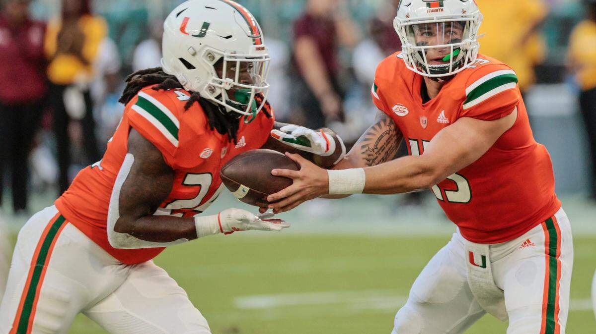 Miami Hurricanes quarterback Jake Garcia (13) hands off to Miami Hurricanes running back Lucious Stanley (24) in the fourth quarter during game against the Bethune Cookman Wildcats at Hard Rock Stadium in Miami Gardens on Saturday, September 3, 2022.