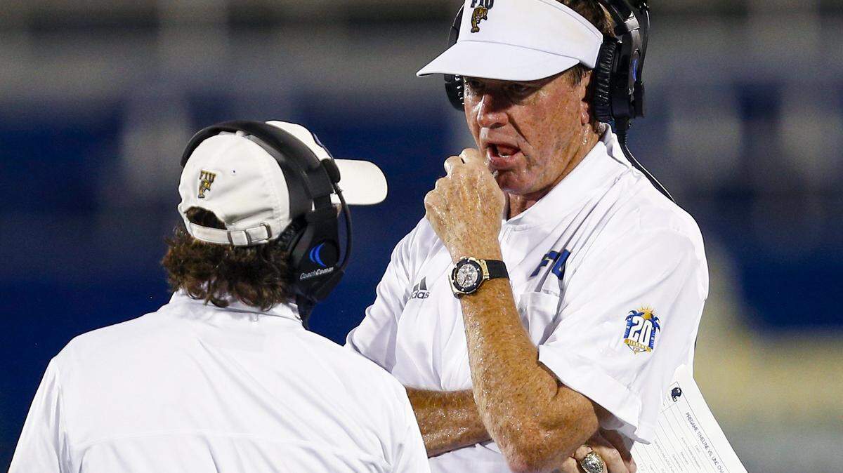 Florida International University Head Coach Butch Davis speaks to an assistant coach on the sidelines during the first quarter of an NCAA Conference USA football game against University of North Carolina at Charlotte 49ers at Riccardo Silva Stadium in Miami, Florida, on Friday, October 8, 2021.