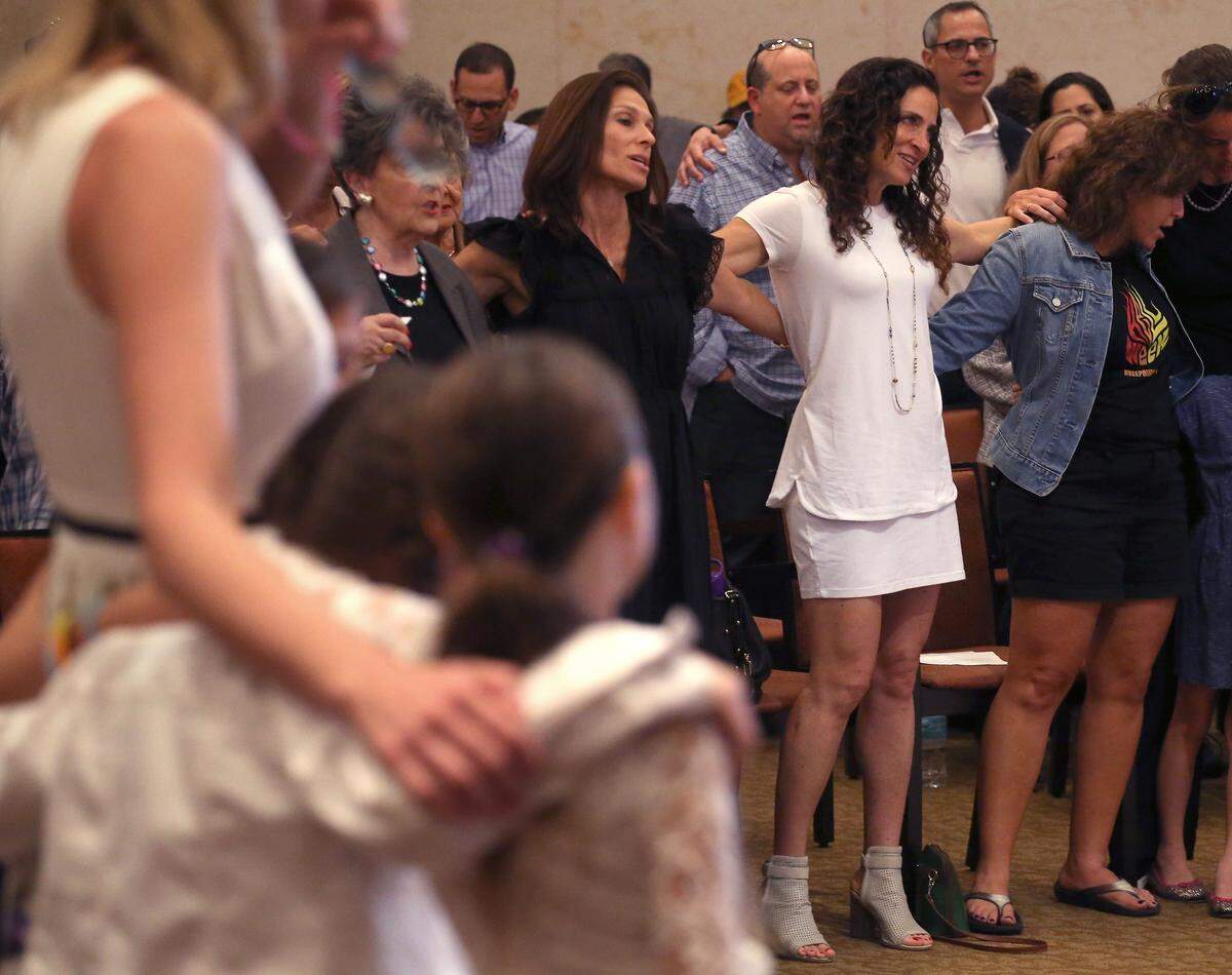 Members of the Beth Sholom synagogue in Miami Beach join arms with each other on Sunday, Oct. 28, 2018, during a “Time to Grieve,” a service to remember victims of the mass shooting at a Pittsburgh temple.