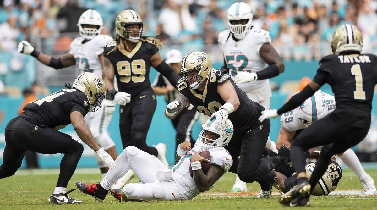 Miami Dolphins quarterback Tua Tagovailoa (1) slides with the ball in the second half of his NFL game against the New Orleans Saints at Hard Rock Stadium on Sunday, Nov. 30, 2025, in Miami Gardens, Fla.