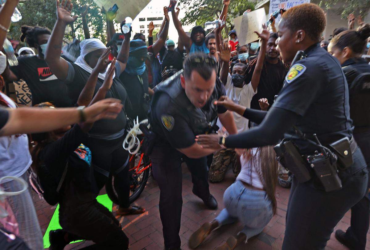 Protesters taking part in a demonstration against police brutality in Fort Lauderdale express outrage after one officer shoves a female participant. The officer was suspended.