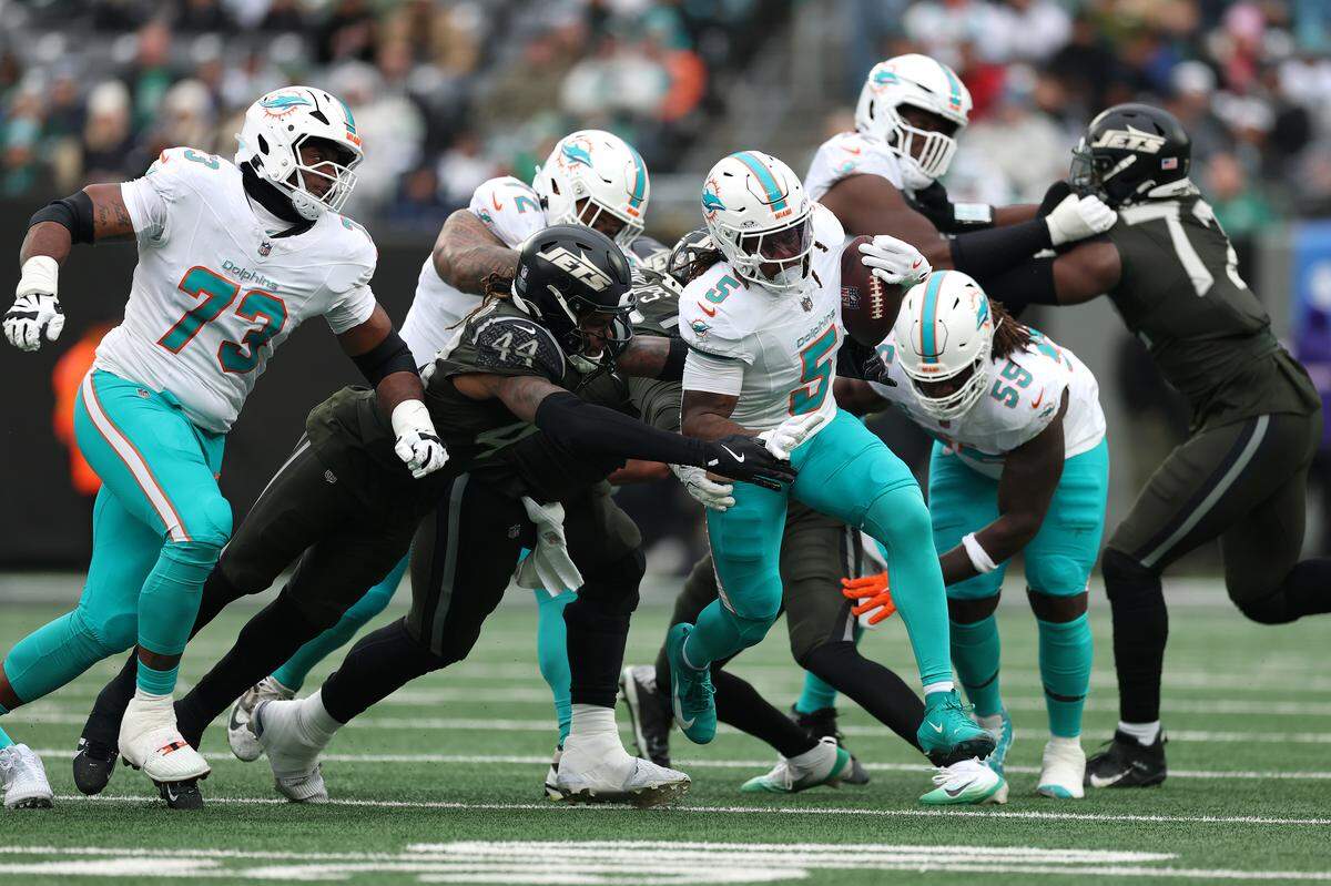 EAST RUTHERFORD, NEW JERSEY - DECEMBER 07: Jamien Sherwood #44 of the New York Jets tackles Jaylen Wright #5 of the Miami Dolphins during the first quarter at MetLife Stadium on December 07, 2025 in East Rutherford, New Jersey. (Photo by Kenneth Richmond/Getty Images)
