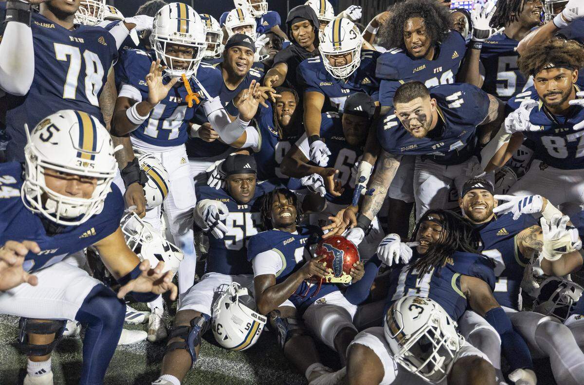 FIU Panthers celebrate with a Florida Atlantic University Owls helmet after winning the Shula Bowl football game at Pitbull Stadium on Saturday, Sept. 13, 2025, in Miami, Fla.