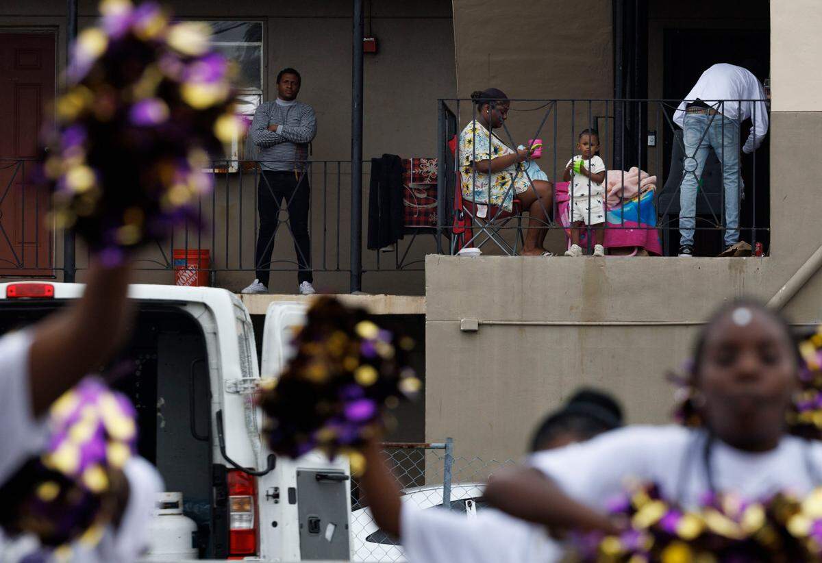 People watch the Dr. Martin Luther King Jr. Day parade pass by from their apartments on Monday, Jan. 20, 2025, in Liberty City in Miami, Fla.