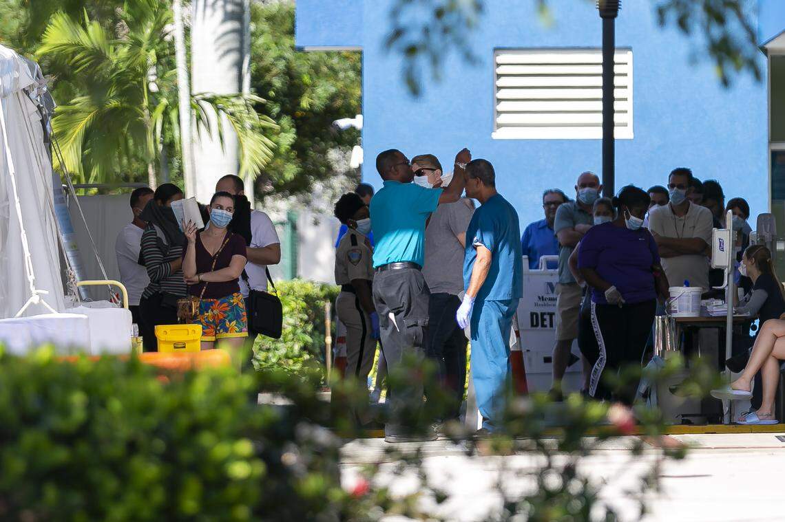 People line up to enter a triage tent outside the emergency room at Memorial West Hospital in Pembroke Pines, Florida, on March 16, 2020.