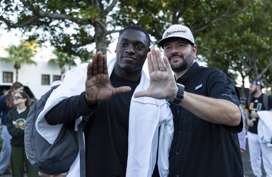 Miami Hurricanes linebacker Wesley Bissainthe (31) throws up the U with a fan near the Hecht Athletic Center on Friday, Jan. 9, 2025, in Coral Gables, Fla. The University of Miami returned home after winning the Fiesta Bowl on Thursday against Ole Miss at State Farm Stadium in Glendale, Ariz.