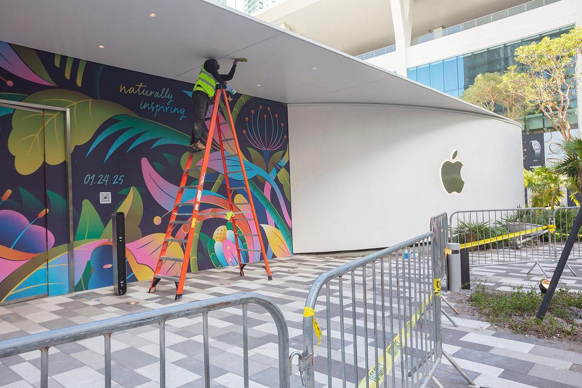 Juan Sosa fixes retouches the front and banner sign of the new Apple Store set to open on Jan. 24, 2025, at Miami Worldcenter in downtown Miami. Apple unveiled the sign and date of opening on Friday, Jan. 10, 2025.