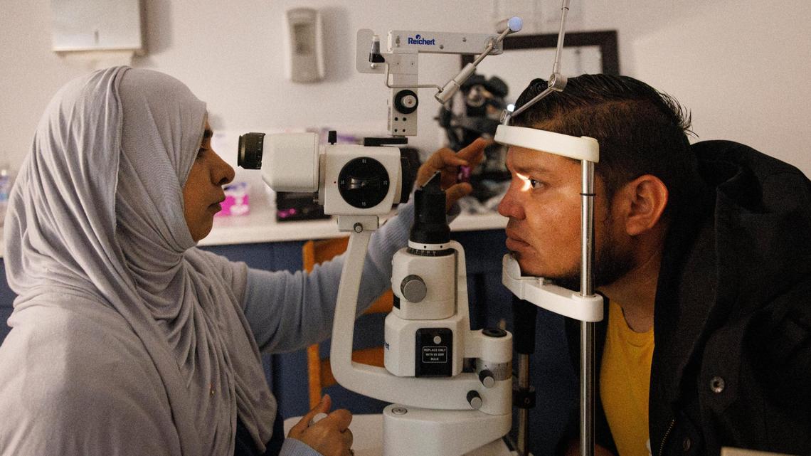 Jose Villatoro, right, receives a free eye exam from Dr. Almas Khan, who helped start the free optometry at the clinic in 2016, inside the UHI CommunityCare Clinic on Monday, Dec. 16, 2024, in Opa-locka, Fla.