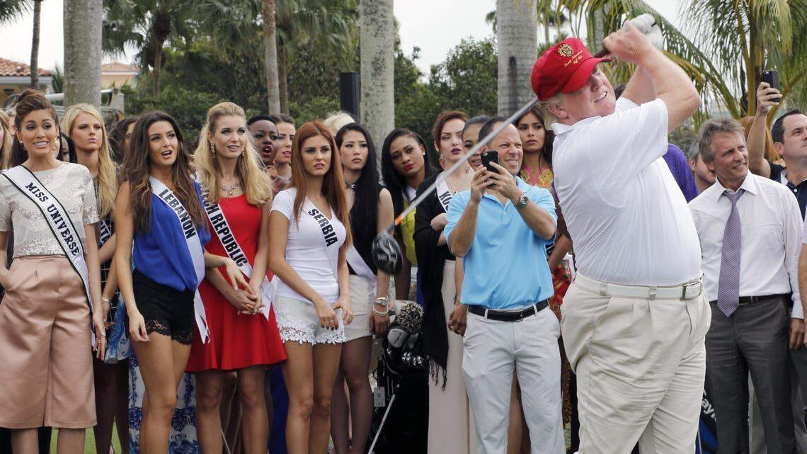 In this January 2015 file photo, Donald Trump, right, tees off on the Red Tiger golf course at Trump National Doral Miami.