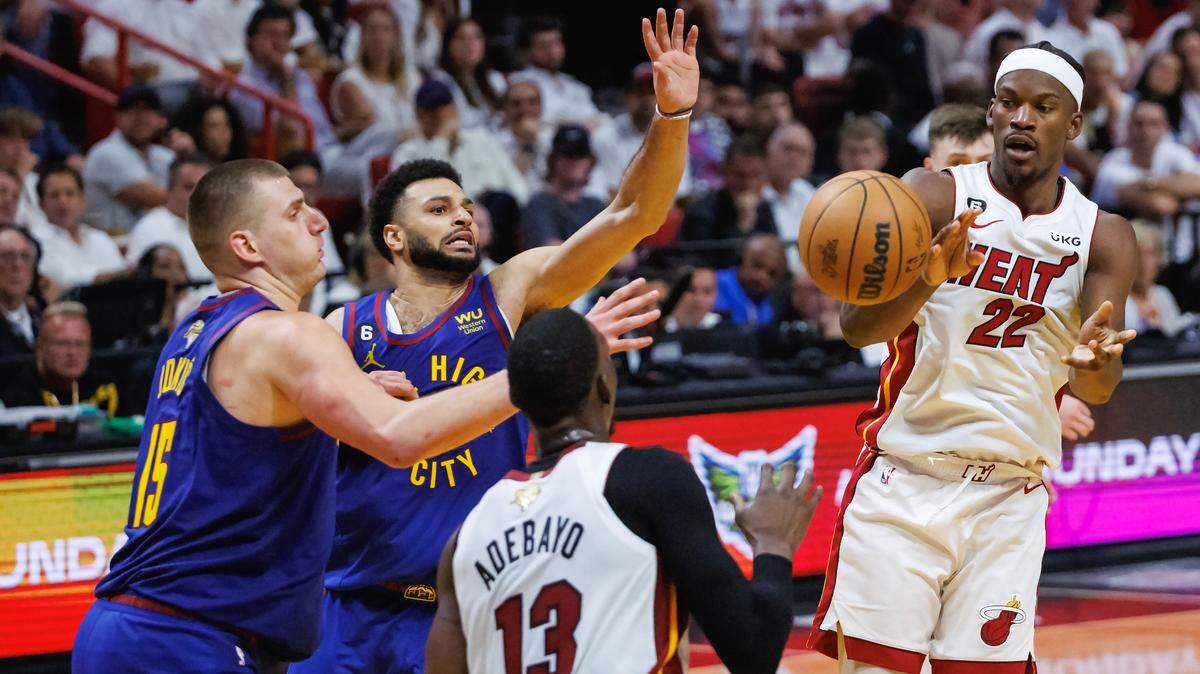 Nuggets center Nikola Jokic (15) and guard Jamal Murray (27) defend Heat forward Jimmy Butler (22) while he passes the ball to Heat center Bam Adebayo (13) during the second half of Game 3 of the NBA Finals at Kaseya Center on June 7, 2023, in Miami.