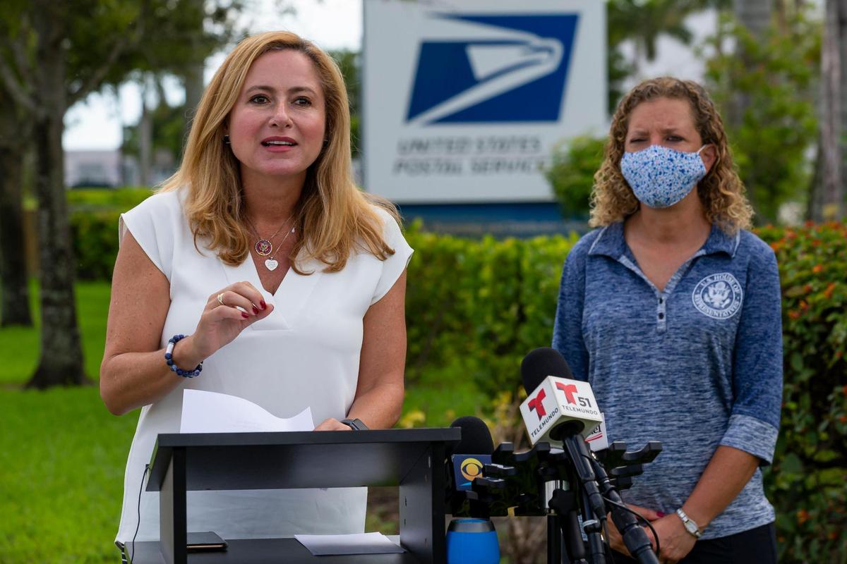 Democratic U.S. Reps. Debbie Mucarsel-Powell, left, and Debbie Wasserman Schultz speak during a press conference near the United States Postal Service mail distribution facility in Opa-locka, Florida on Tuesday, August 18, 2020. Democrats spoke about their plans to protect the USPS and how they will work to ensure access to the ballot during this election season.