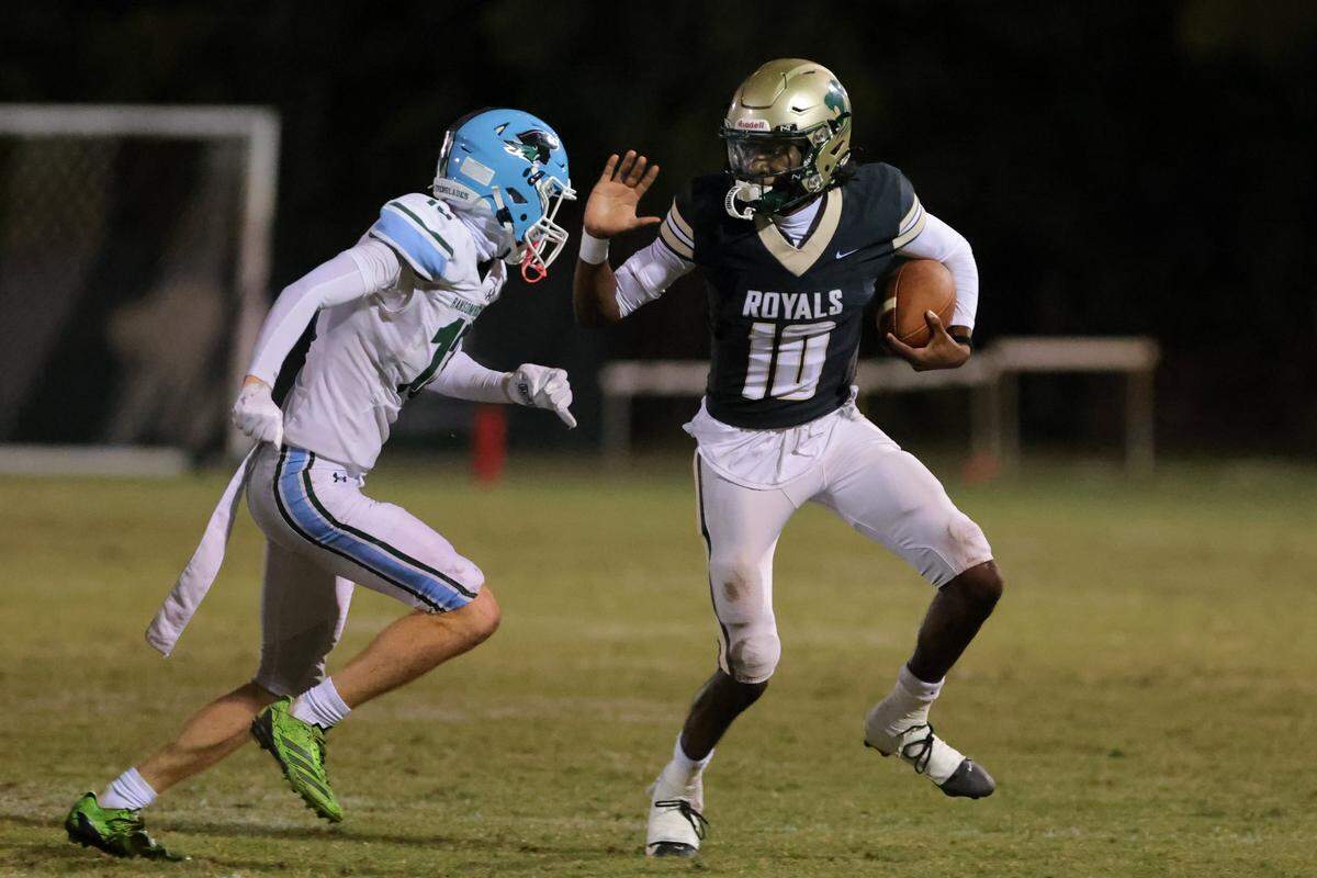 Immaculata-La Salle quarterback Nate Merrell Jr. (10) carries the football against Ransom Everglades wide receiver Finn Mccarron (13) during the second quarter of a Region 4-2A semifinal playoff game at Immaculata-La Salle High School on Friday, Nov. 21, in Miami, Fla.