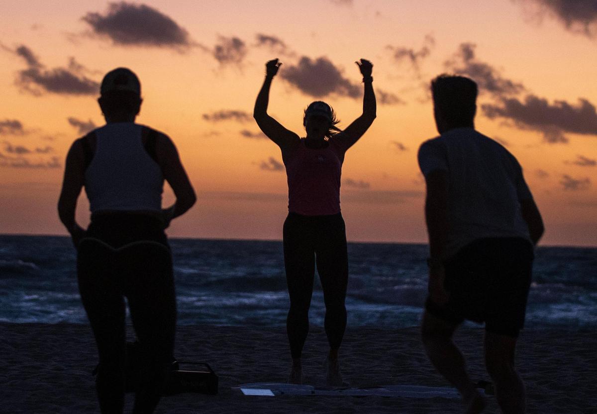 Certified personal trainer Kristen Smith (center), leads a fitness class in the sand on Tuesday, Jan. 23, 2024, as part of her program Miami Beach Fit Camp. She has lost more than 240 pounds since 2006. She will run her first Life Time Miami Marathon on Sunday, Jan. 28.