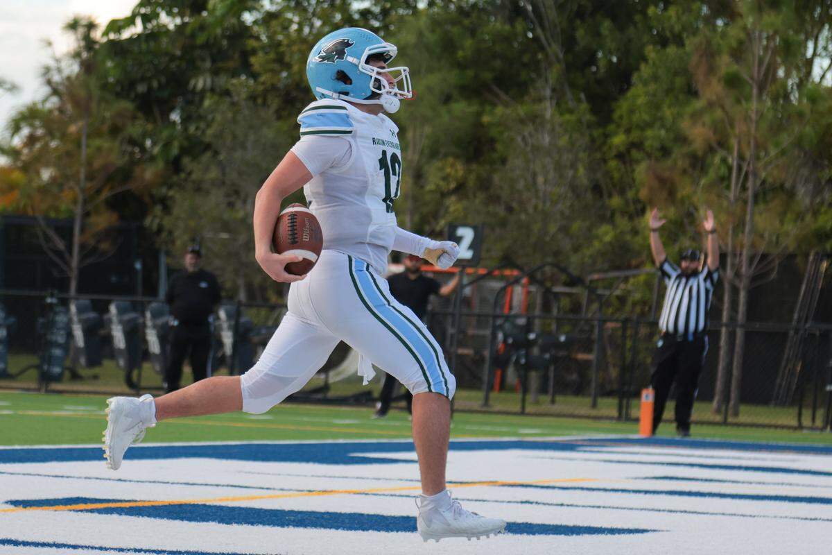 Ransom Everglades quarterback Matthew Guevara (12) scores a touchdown against Gulliver Prep during the fourth quarter of a Region 4-2A quarterfinal football playoff game at Gulliver Prep in Pinecrest, Florida, Friday, Nov. 14, 2025.